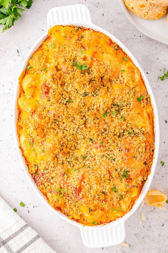 Crab Macaroni and Cheese (with Crispy Breadcrumb Topping) A frying pan with minced garlic sizzling in melted butter, surrounded by small bowls containing spices on a light countertop.